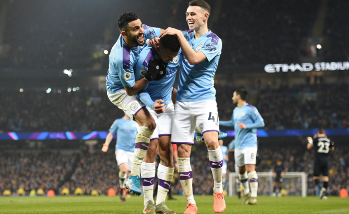Manchester City’s Brazilian striker Gabriel Jesus (C) celebrates with Manchester City’s Algerian midfielder Riyad Mahrez (L) and Manchester City’s English midfielder Phil Foden (R) after scoring the opening goal of the English Premier League football match between Manchester City and Everton at the Etihad Stadium in Manchester, north west England, on January 1, 2020. (Photo by Oli SCARFF / AFP) / RESTRICTED TO EDITORIAL USE. No use with unauthorized audio, video, data, fixture lists, club/league logos or ’live’ services. Online in-match use limited to 120 images. An additional 40 images may be used in extra time. No video emulation. Social media in-match use limited to 120 images. An additional 40 images may be used in extra time. No use in betting publications, games or single club/league/player publications. / (Photo by OLI SCARFF/AFP via Getty Images)
